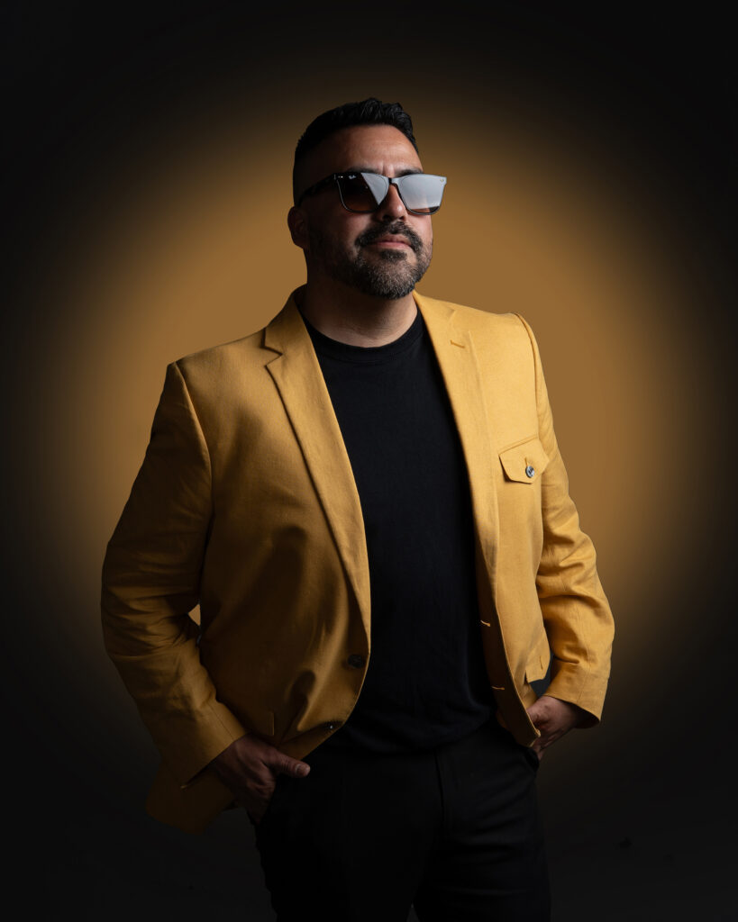 RETRATO DE MODELO CON LENTES Y SACO COLOR MOSTAZA Y PANTALON NEGRO ELEGANTE
