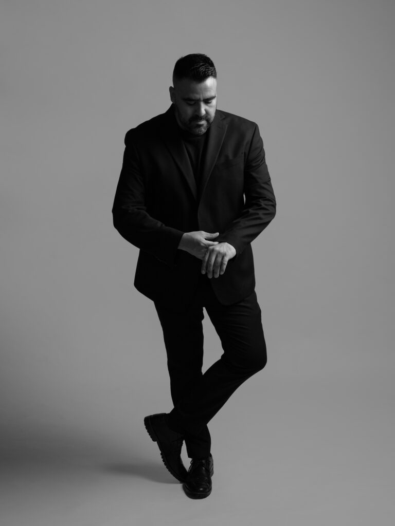 RETRATO DE MODELO CON SACO NEGRO Y PANTALON NEGRO ELEGANTE FOTOGRAFIA EN BLANCO Y NEGRO