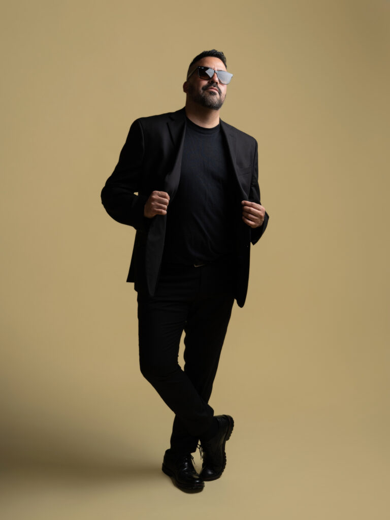 RETRATO DE MODELO CON LENTES Y SACO COLOR MOSTAZA Y PANTALON NEGRO ELEGANTE