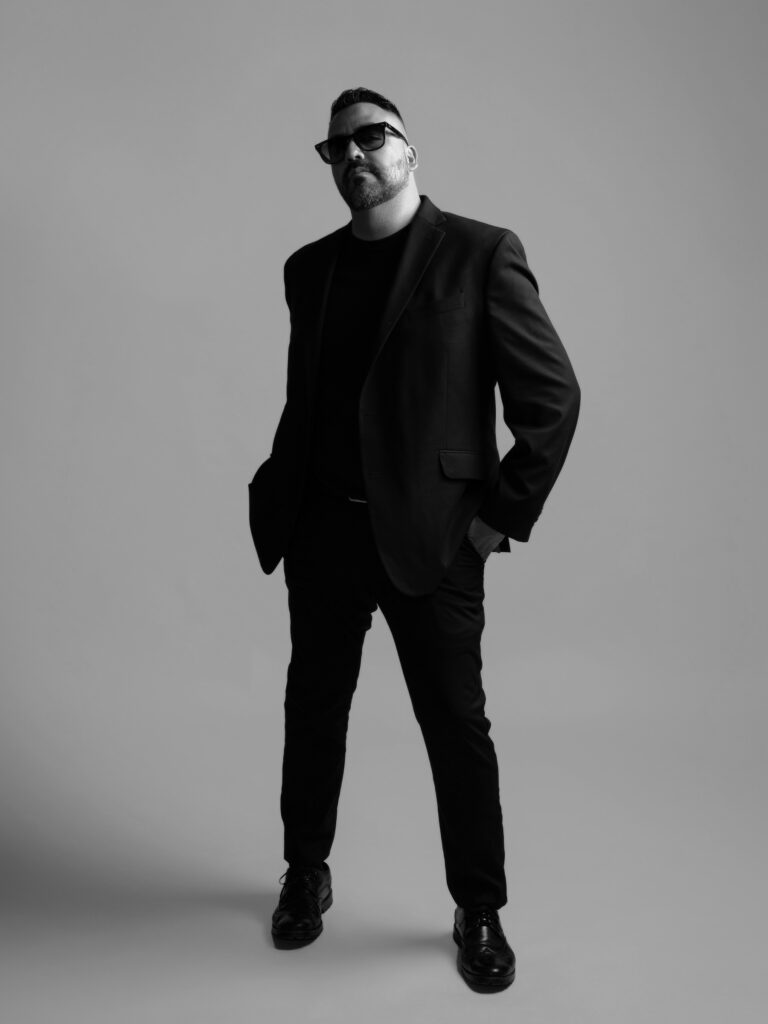 RETRATO DE MODELO CON SACO NEGRO Y PANTALON NEGRO ELEGANTE FOTOGRAFIA EN BLANCO Y NEGRO
