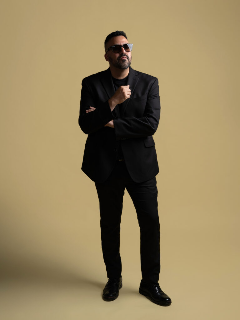 RETRATO DE MODELO CON LENTES Y SACO COLOR MOSTAZA Y PANTALON NEGRO ELEGANTE