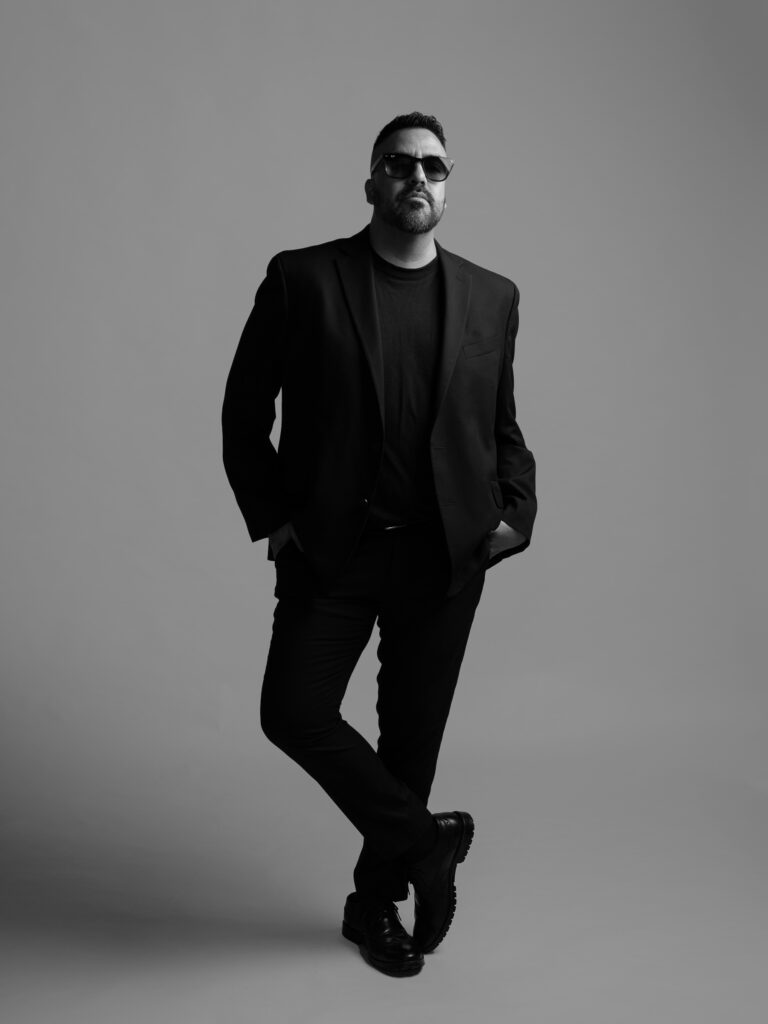 RETRATO DE MODELO CON SACO NEGRO Y PANTALON NEGRO ELEGANTE FOTOGRAFIA EN BLANCO Y NEGRO