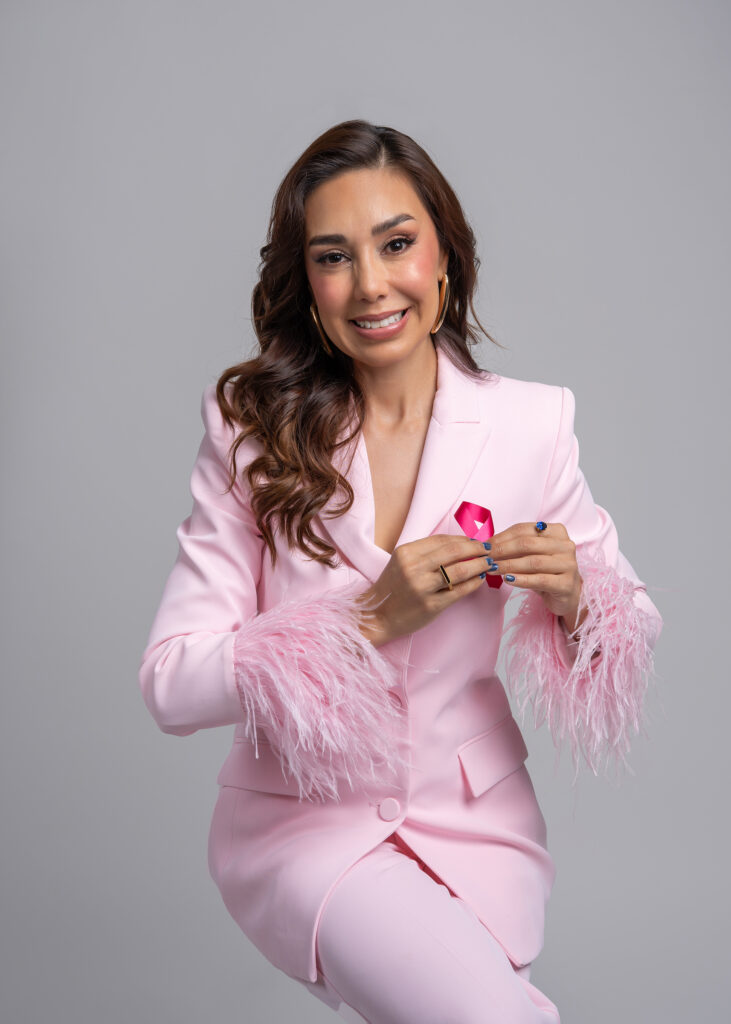 CONDUCTORA DE TELEVISION VESTIDO CON UN TRAJE EN COLOR ROSA EN FONDO BLANCO