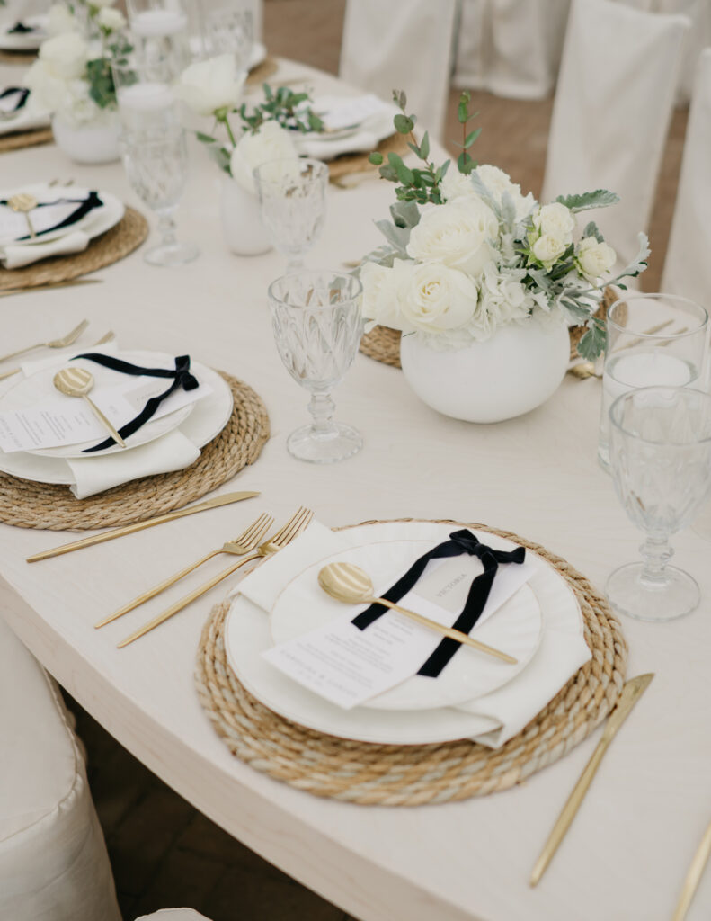 FOTOGRAFIA DEL MONTAJE EN DONDE SE VE LA DECORACION DE LA MESA Y APARECE EL PLATO Y BAJO PLATO JUNTO CON EL MENU IMPRESO, CUCHARA, TENEDOR Y CUBIERTO