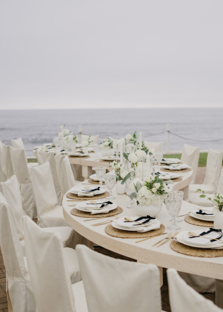 FOTOGRAFIA DEL MONTAJE EN DONDE SE VE LA DECORACION DE LA MESA, FLORES, COPAS, PLATO Y BAJO PLATO JUNTO CON EL MENU IMPRESO, CUCHARA, TENEDOR Y CUBIERTO