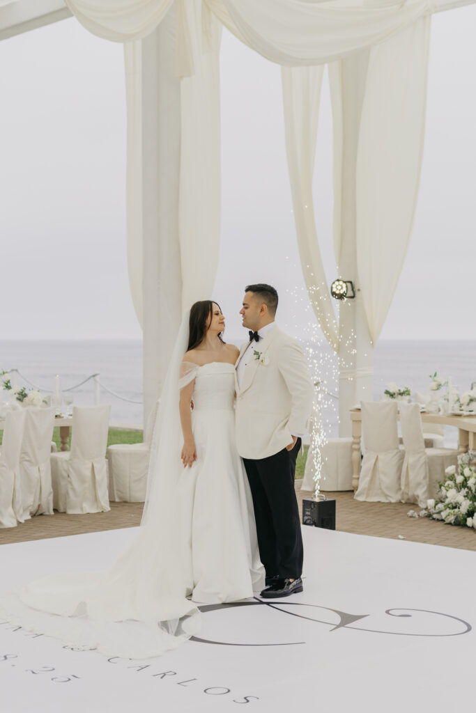 FOTOGRAFIA DE NOVIOS VIENDOSE DE FRENTE Y ABRAZADOS FRENTE AL MAR EN VENTANA AL MAR VENUE EN COLOR