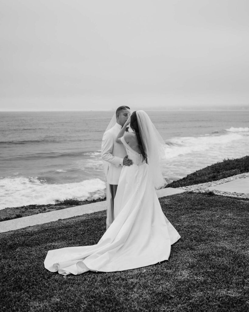 FOTOGRAFIA DE NOVIOS CUBIERTOS POR EL VELO FRENTE AL MAR EN VENTANA AL MAR VENUE